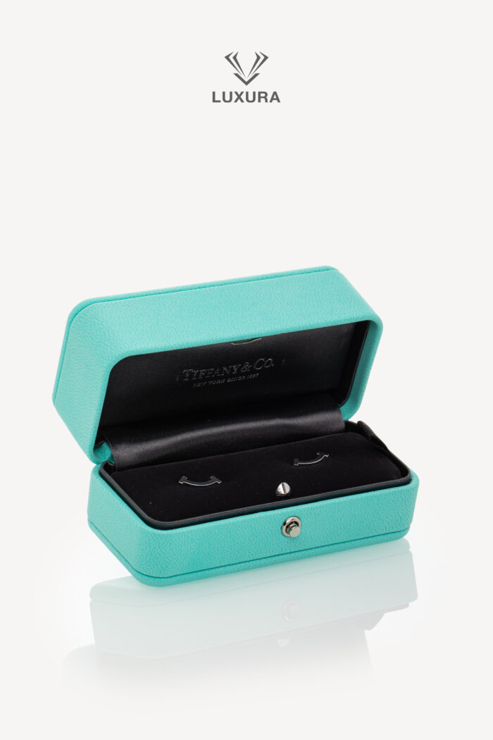<span style="font-size: 10px; color: rgb(101, 101, 101);letter-spacing: .15em;">HARD TO FIND</span><br><strong> TIFFANY & CO. </strong><br><div style="margin-top:10px; font-size:16px;">T Smile Mini Earrings in White Gold</div><br>